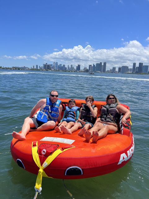 Miami: Adventure Cruise with Jetski, Tubing, and Drinks - Holding on during the tubing and banana boat ride